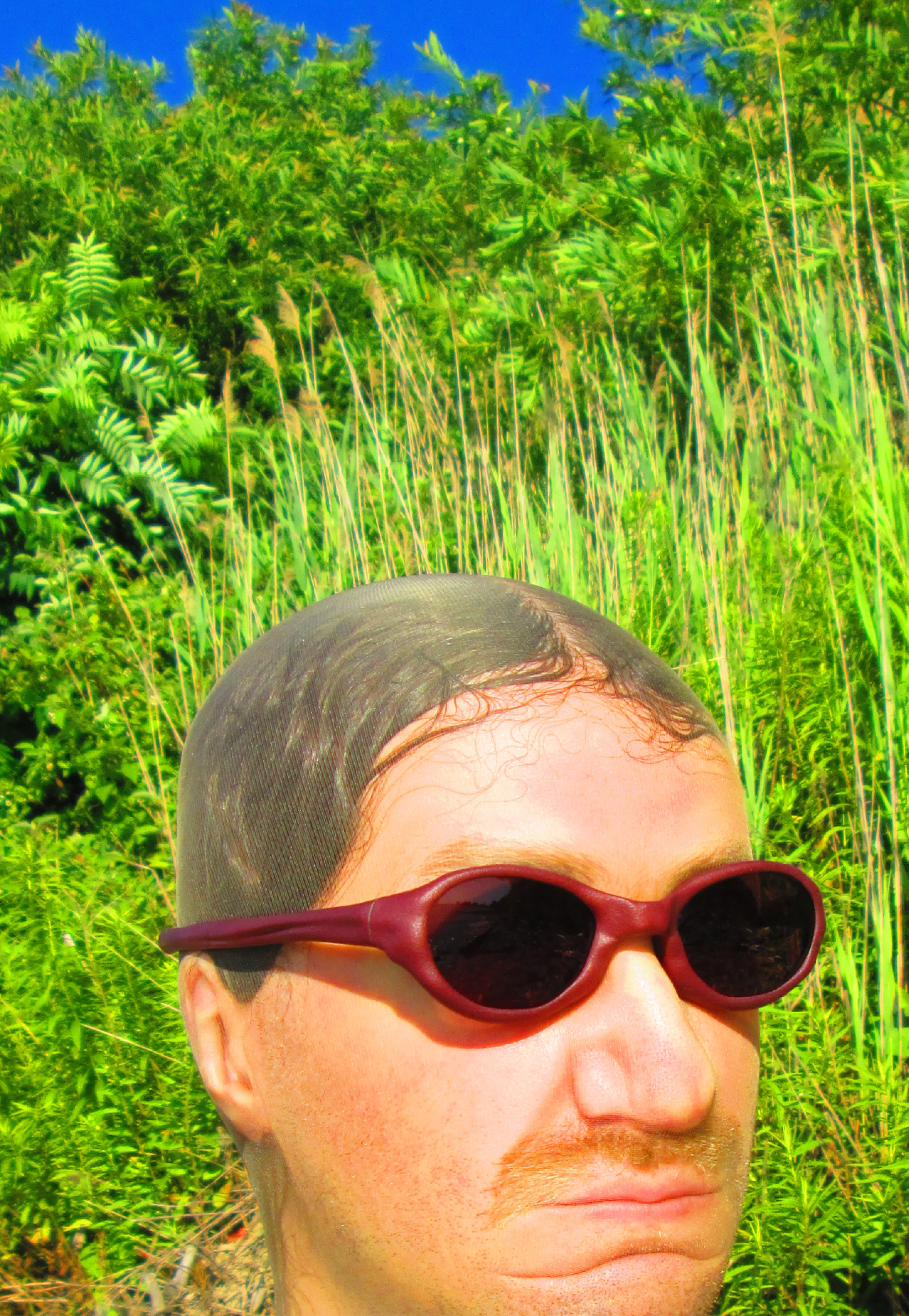 3D render of a bald model wearing black sunglasses with transparent grey lenses